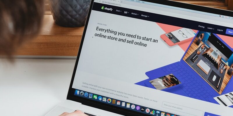 person using macbook pro on white table